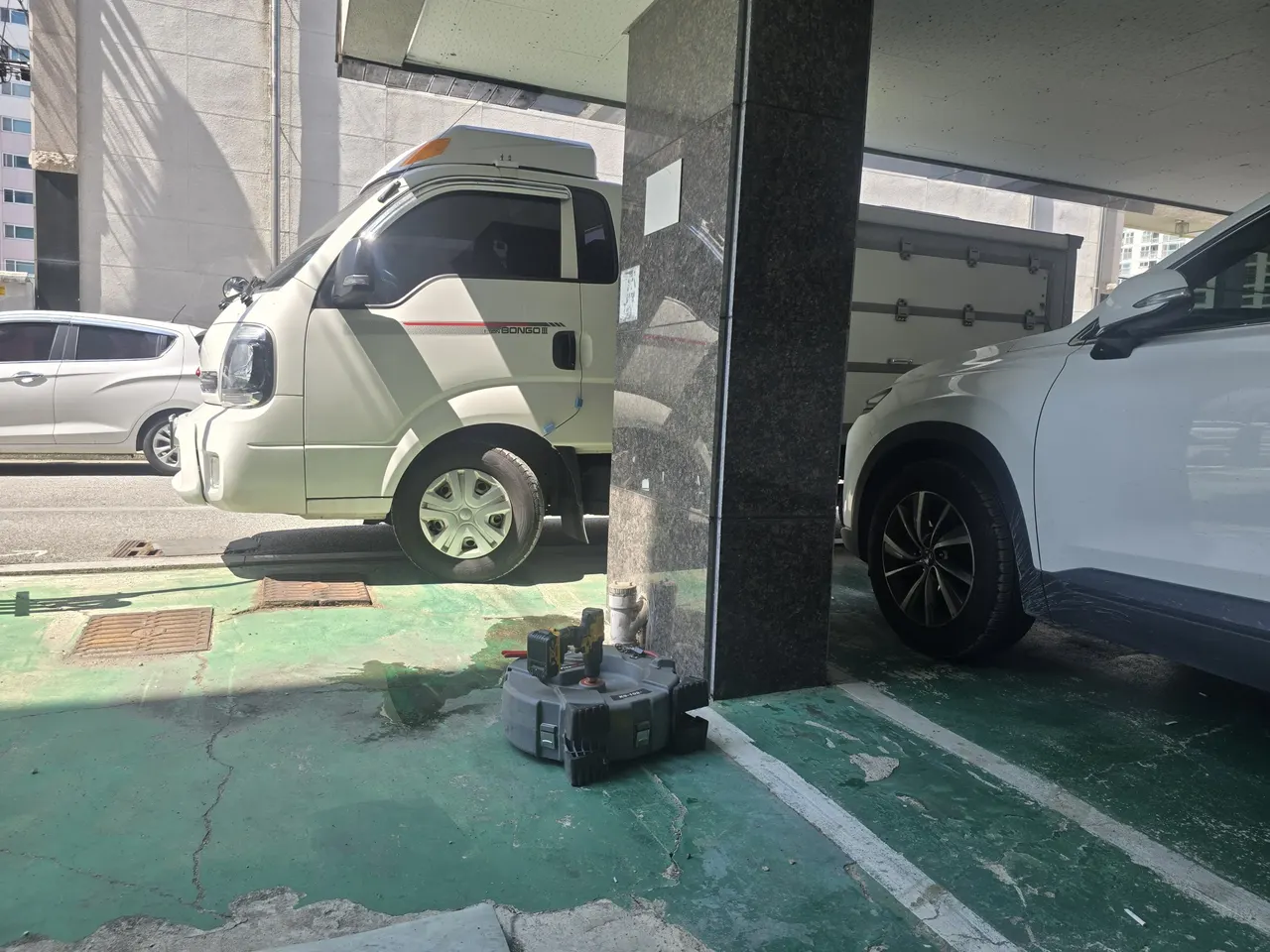 같은 지하주차장 현장에서 다른 각도로 촬영한 전동스프링릴 장비와 드릴